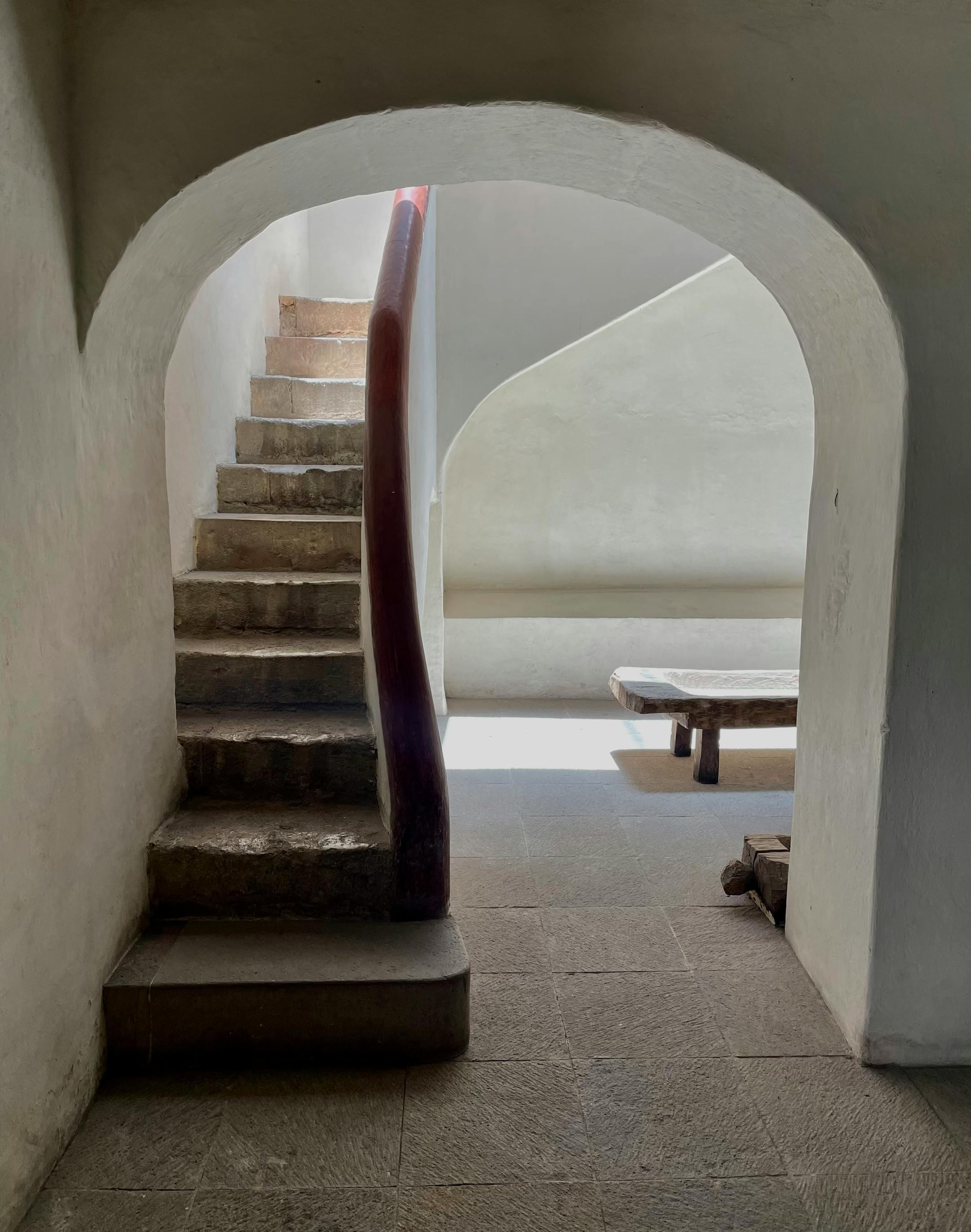 Sunlit minimalist interior with stone staircase in San Miguel de Allende.