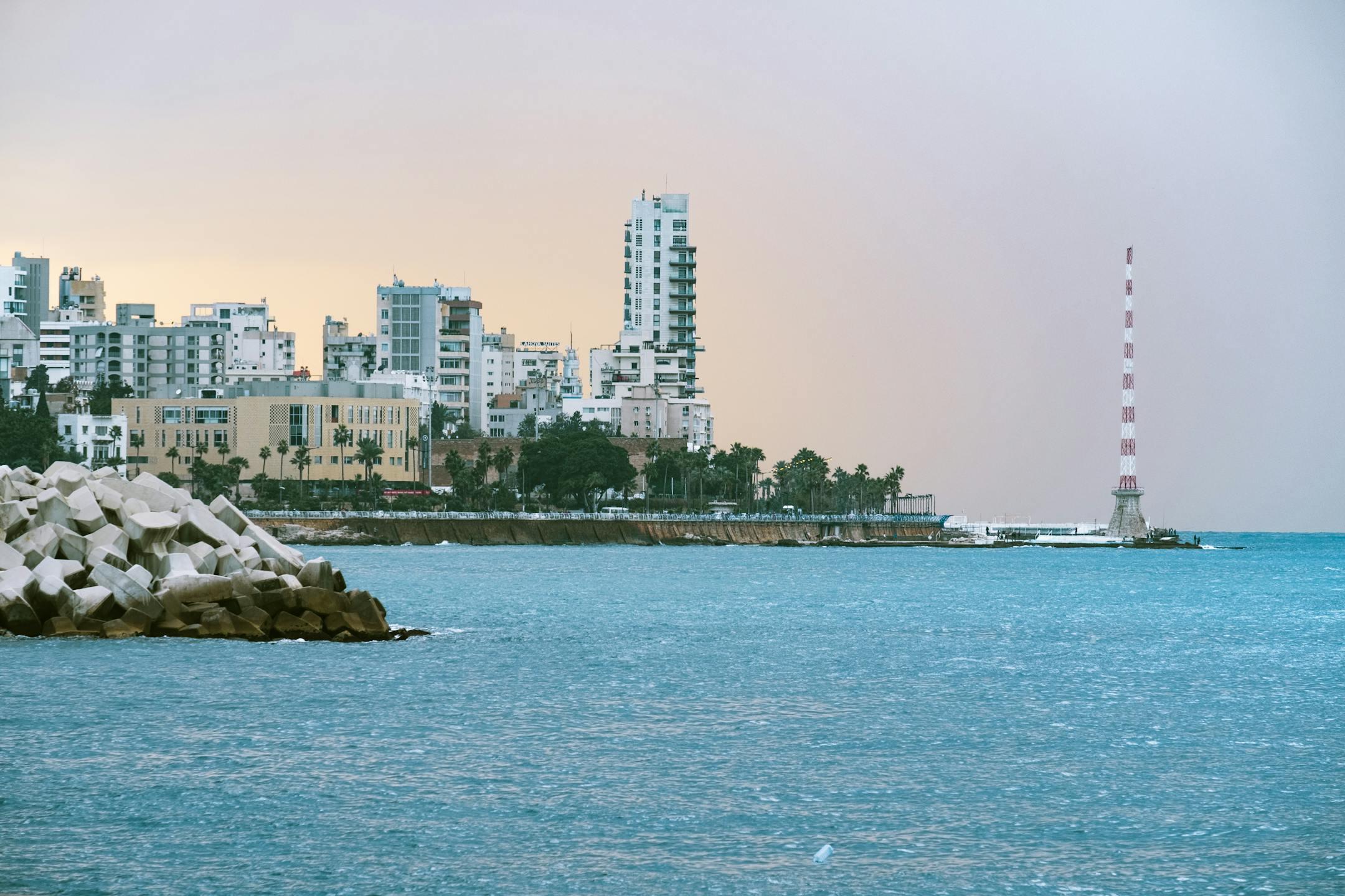Scenic view of Beirut's urban skyline at sunset with the sea and distinctive architecture.