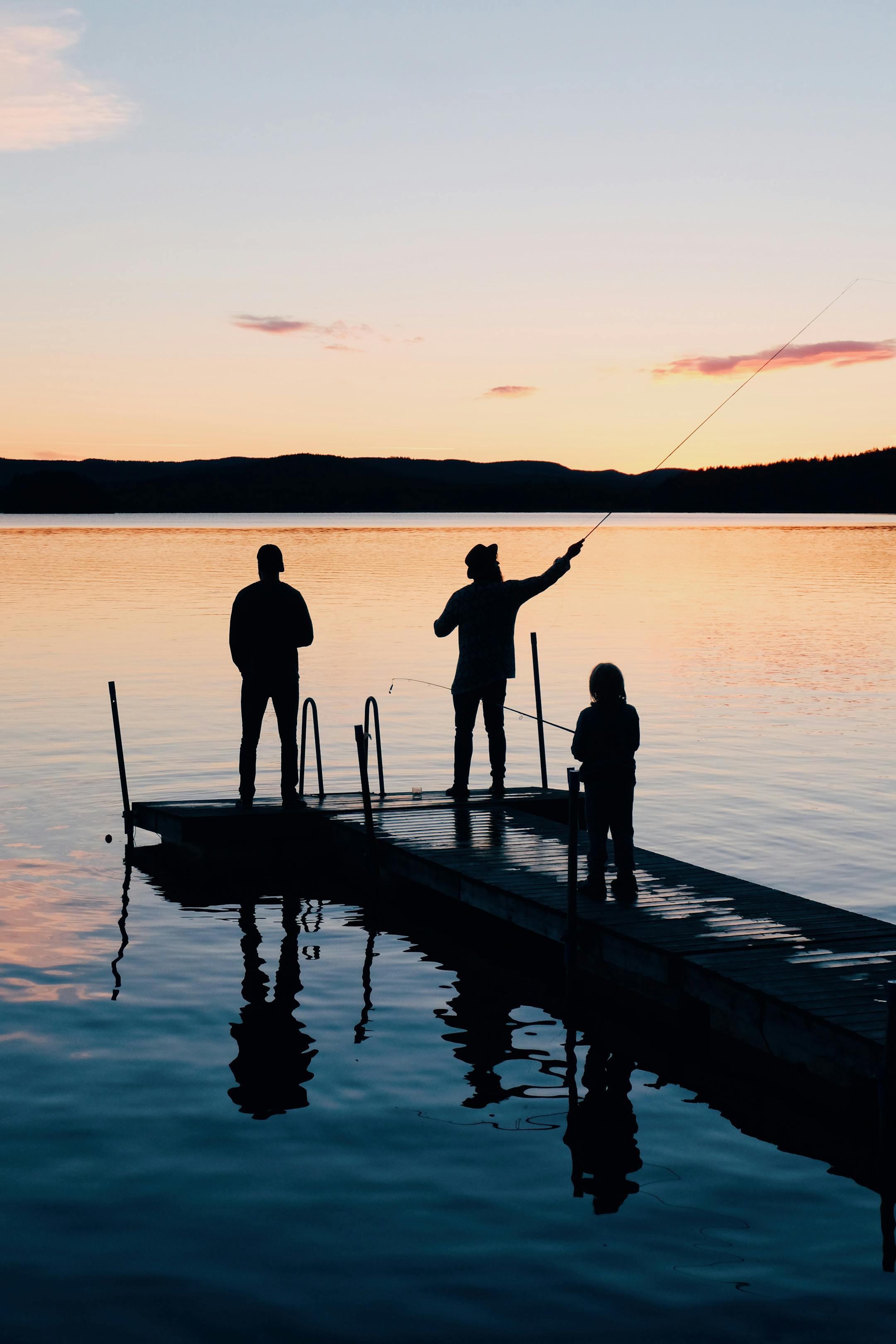 A Lebanese family fishing together at sunset, reflected on the calm lake—Cognitive Analytica family therapy symbolizing patience, trust, and emotional connection.