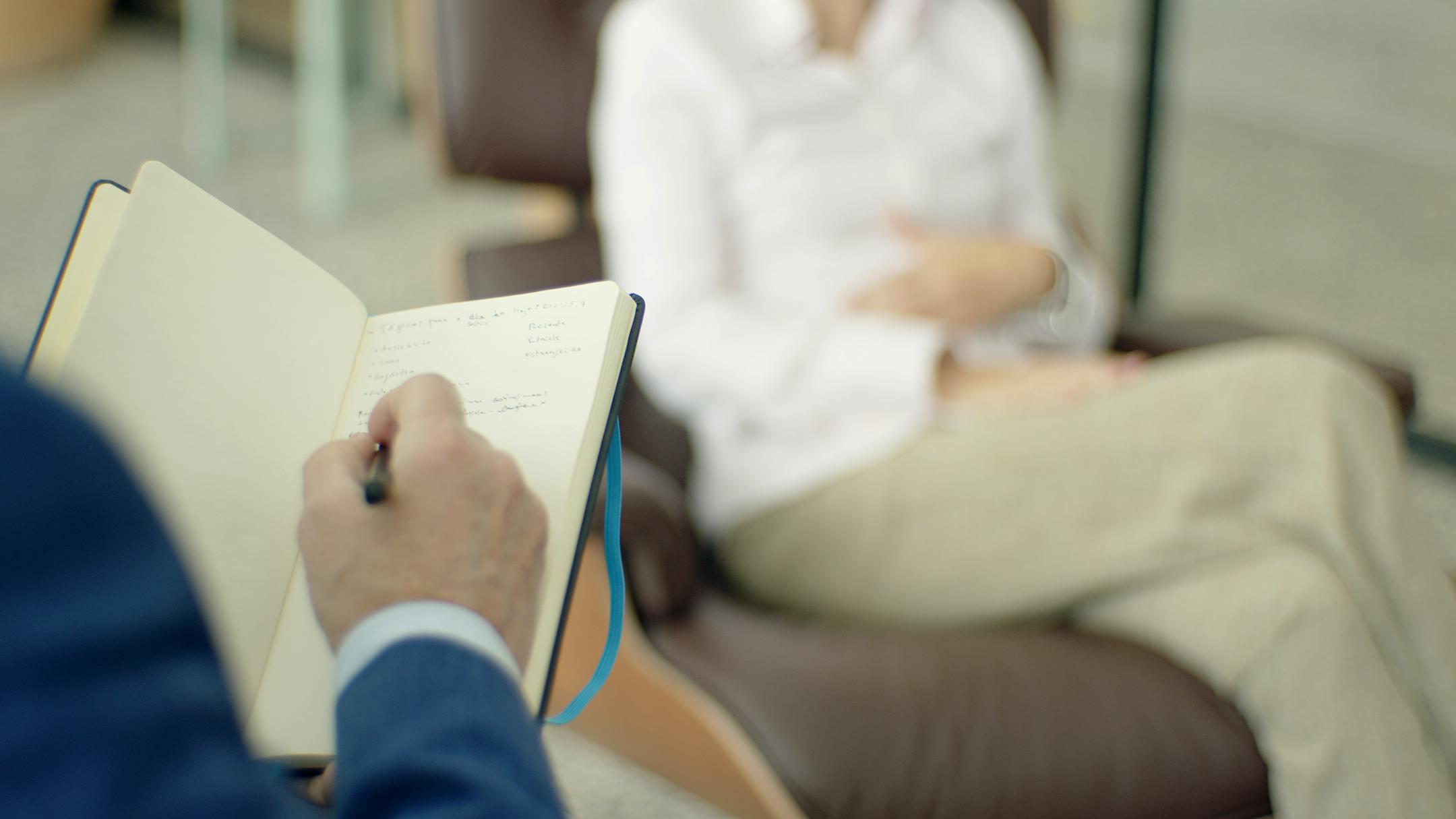 Licensed clinical psychologist in Lebanon taking notes during a counseling session — Cognitive Analytica provides evidence-based mental health care.