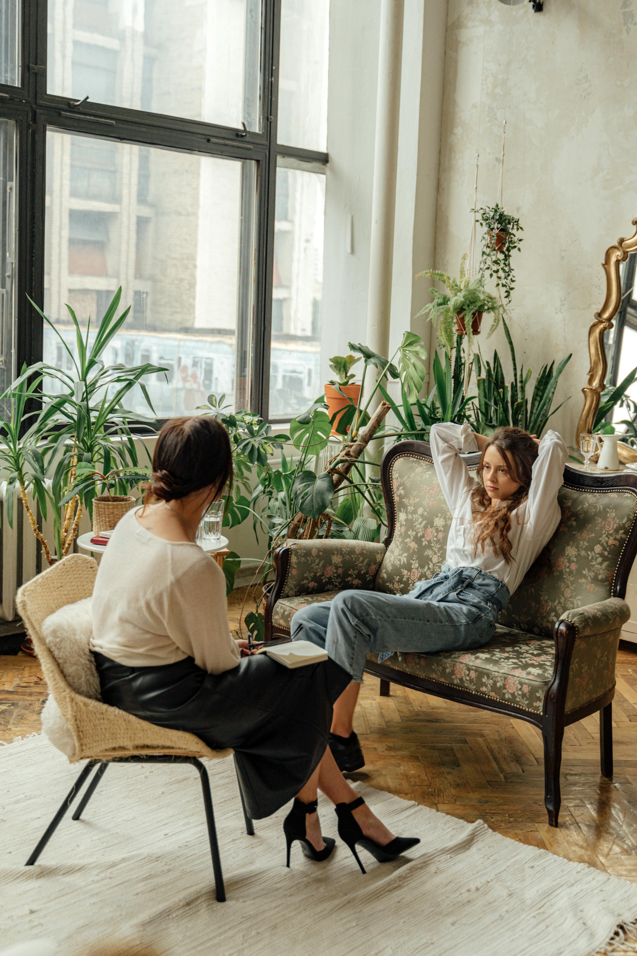 Two women engaged in a counseling session in a cozy, plant-filled living room, symbolizing affordable therapy in Lebanon by Cognitive Analytica.