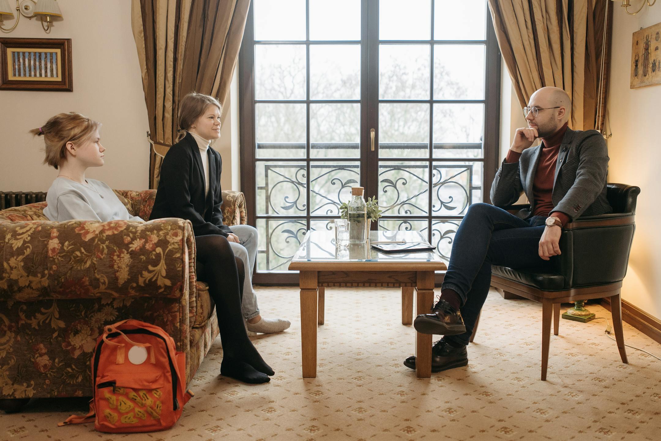 Intimate counseling session with people sitting and talking in a cozy office.