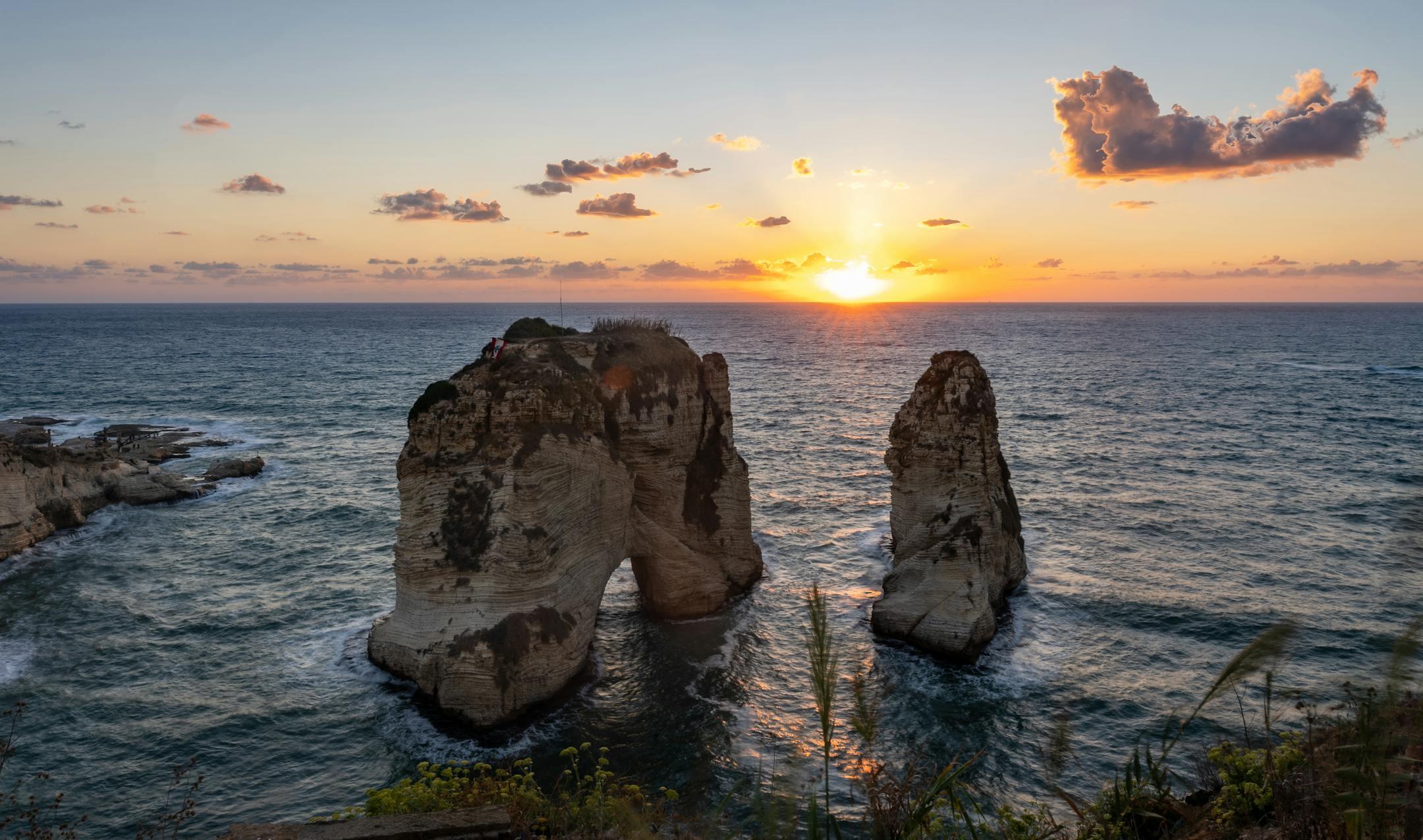Stunning sunset view of Pigeon Rocks in Beirut's oceanic horizon.