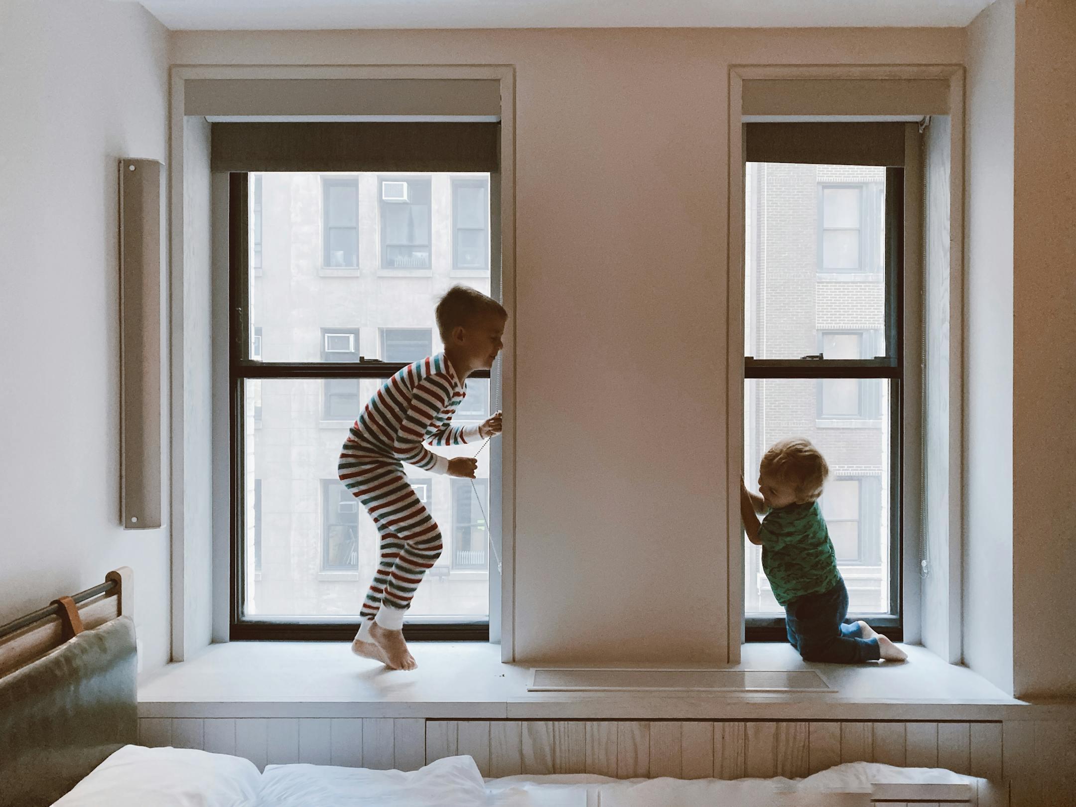 Two children laughing and playing on a window seat in a cozy home—Cognitive Analytica family therapy in Lebanon highlighting joy, bonding, and emotional well-being.