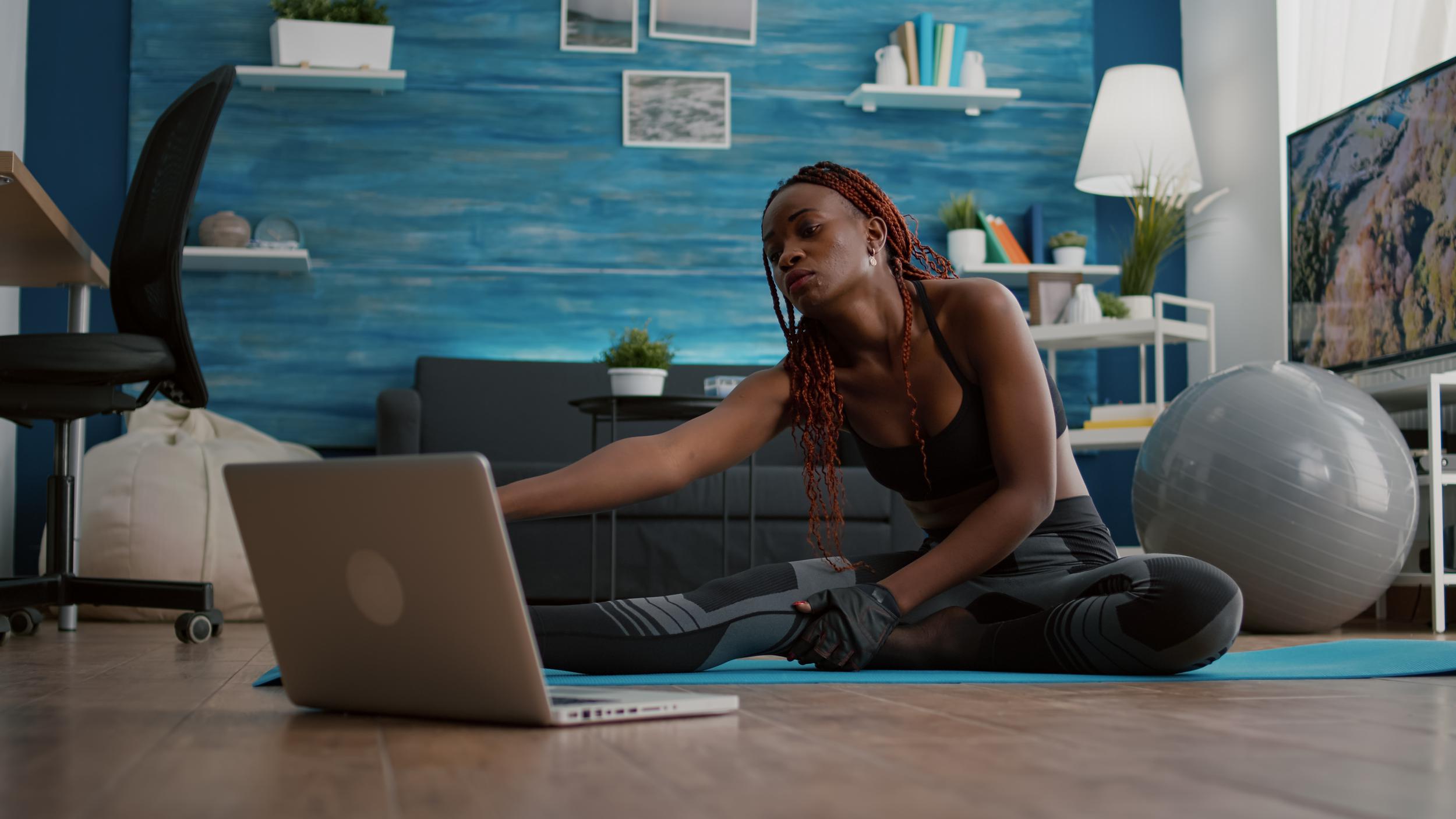 woman-with-dark-skin-doing-pilates-workout-living-room-stretching-body-muscles-yoga-map-while-watching-online-fitness-sport-video-laptop-flexible-adult-enjoying-healthy-lifestyle.jpeg