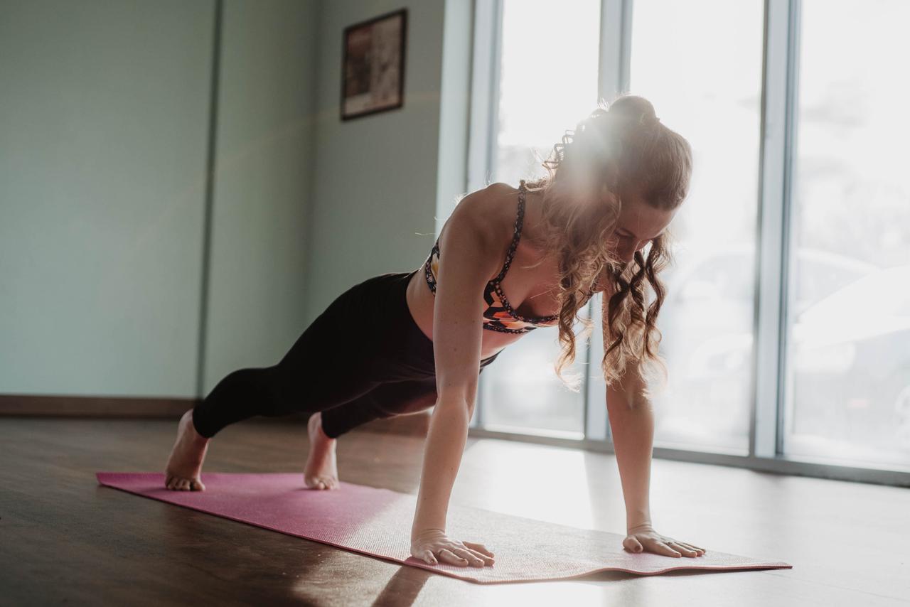 Photo by Olivia Bauso of a girl doing a plank on a pink yoga mat