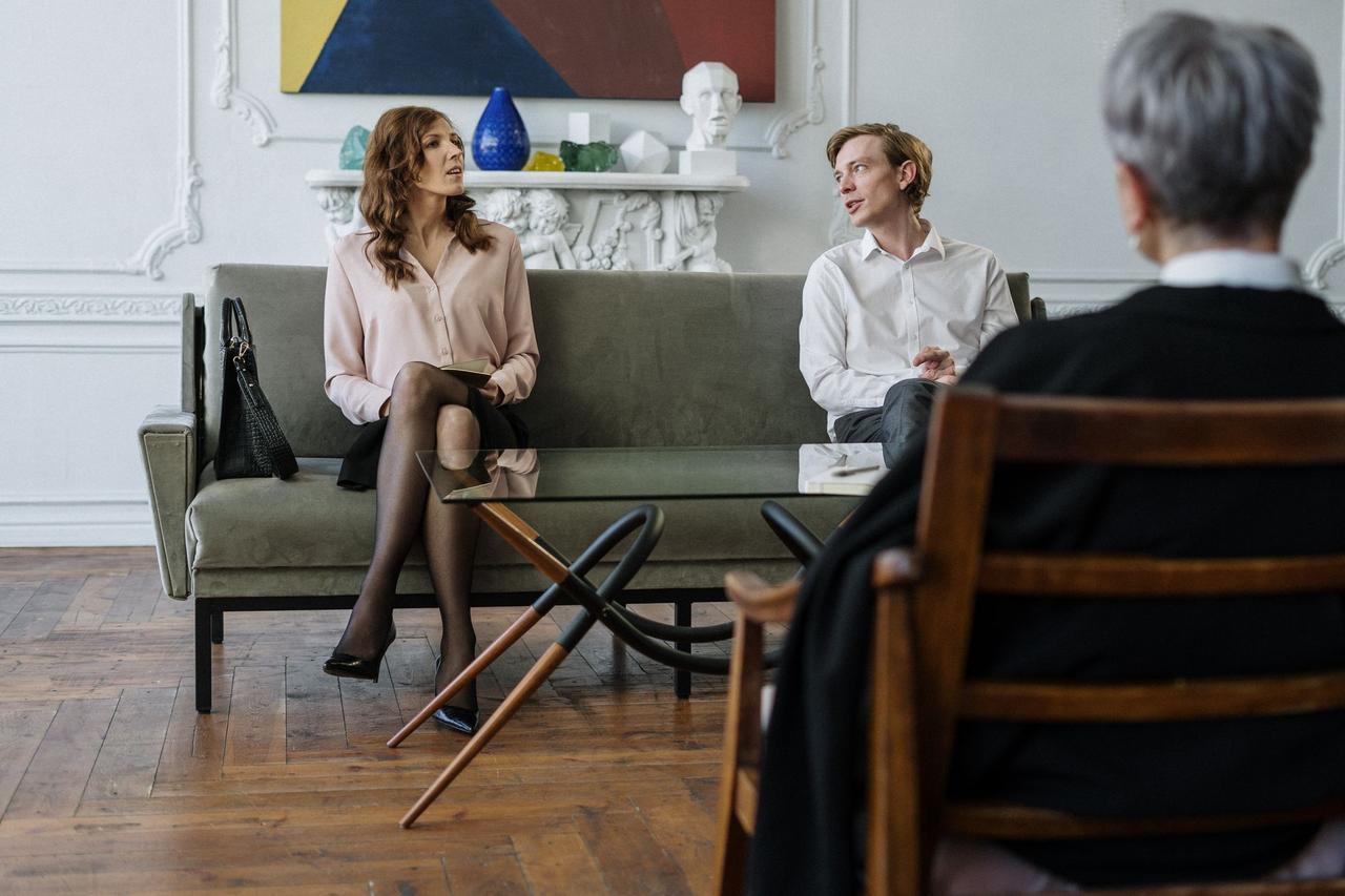 A couple having a discussion with a counselor in a modern office setting.