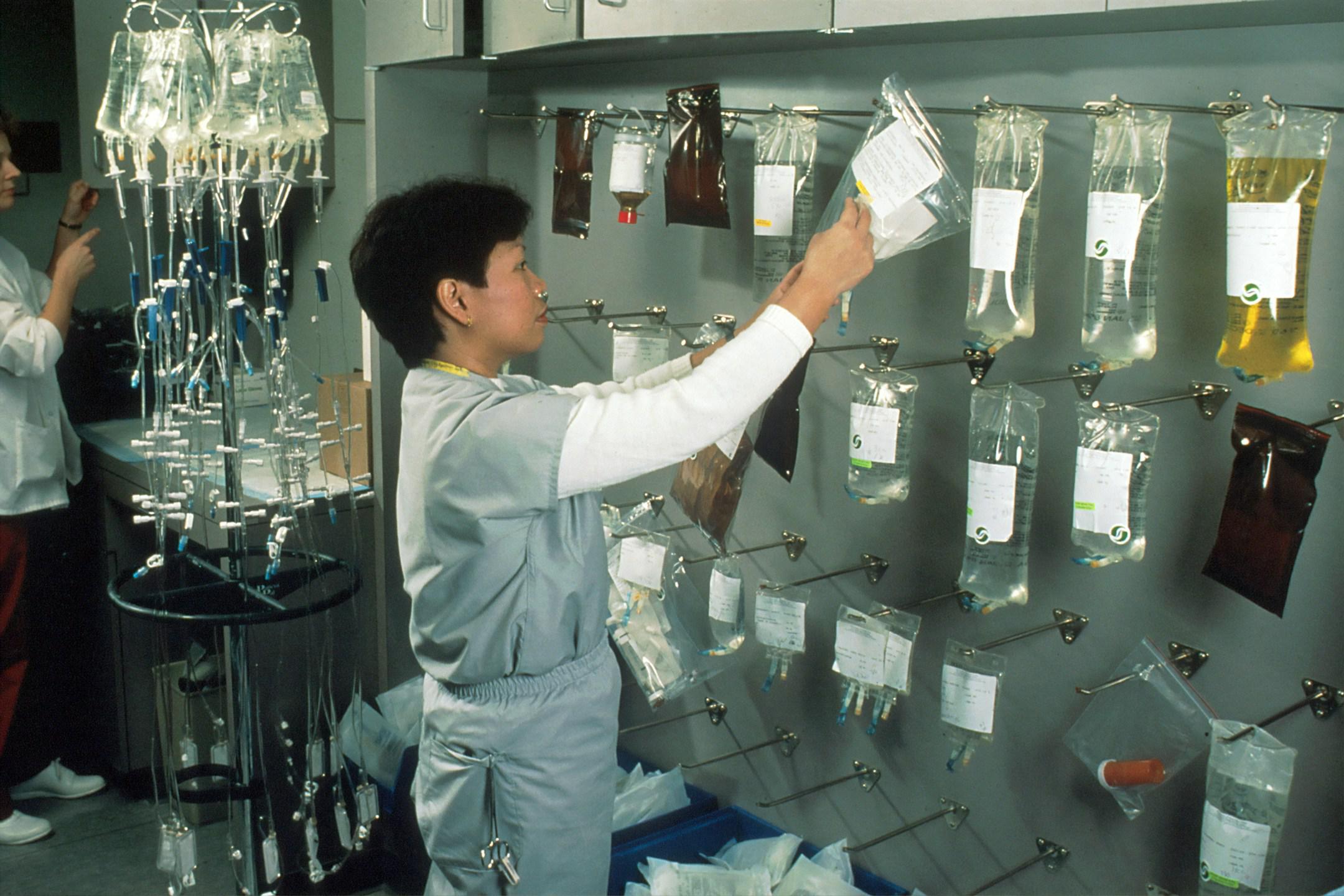 Asian female nurse hanging bags of chemotherapy drugs. 1989