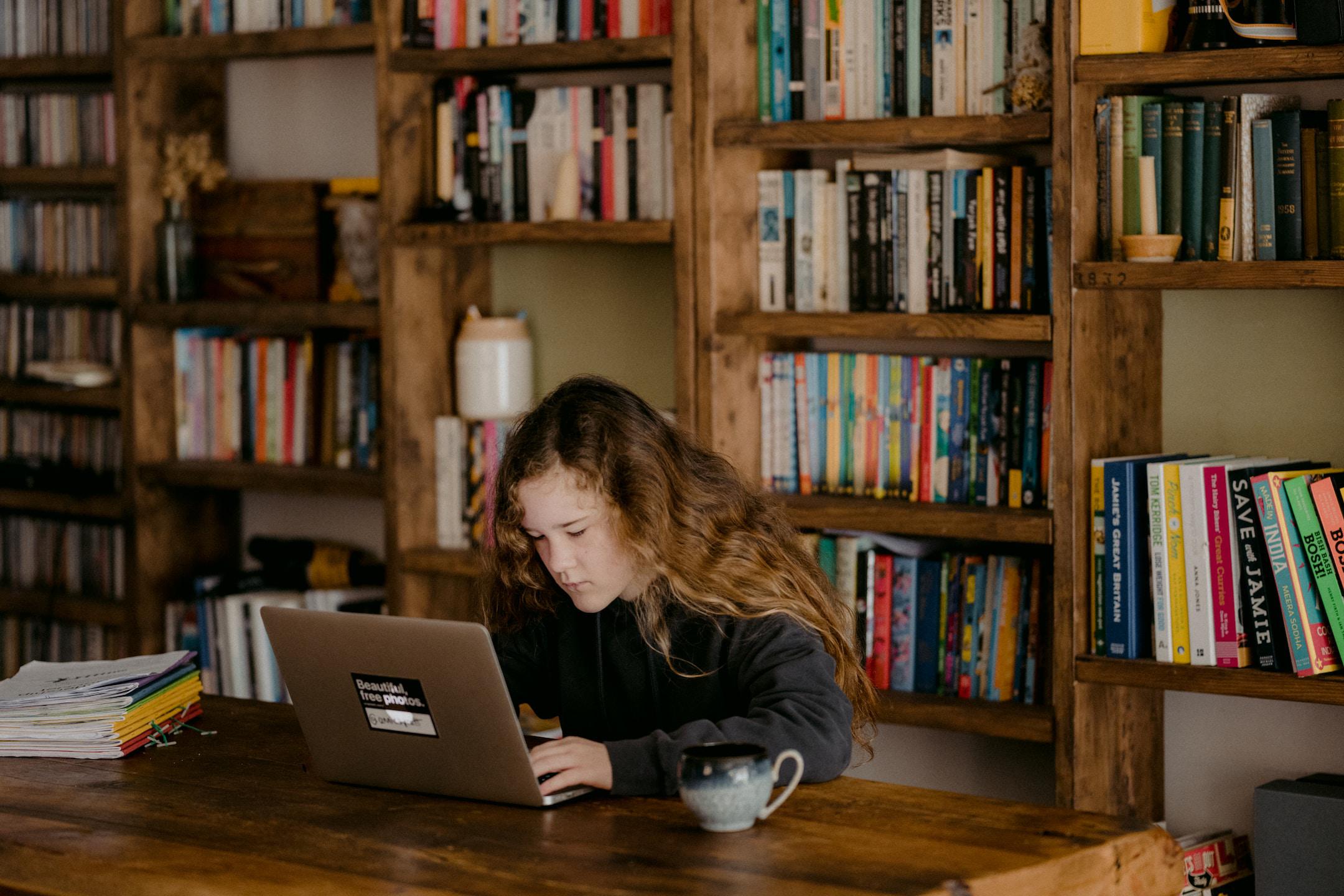 Young teen doing schoolwork at home after UK schools close due to the Coronavirus.