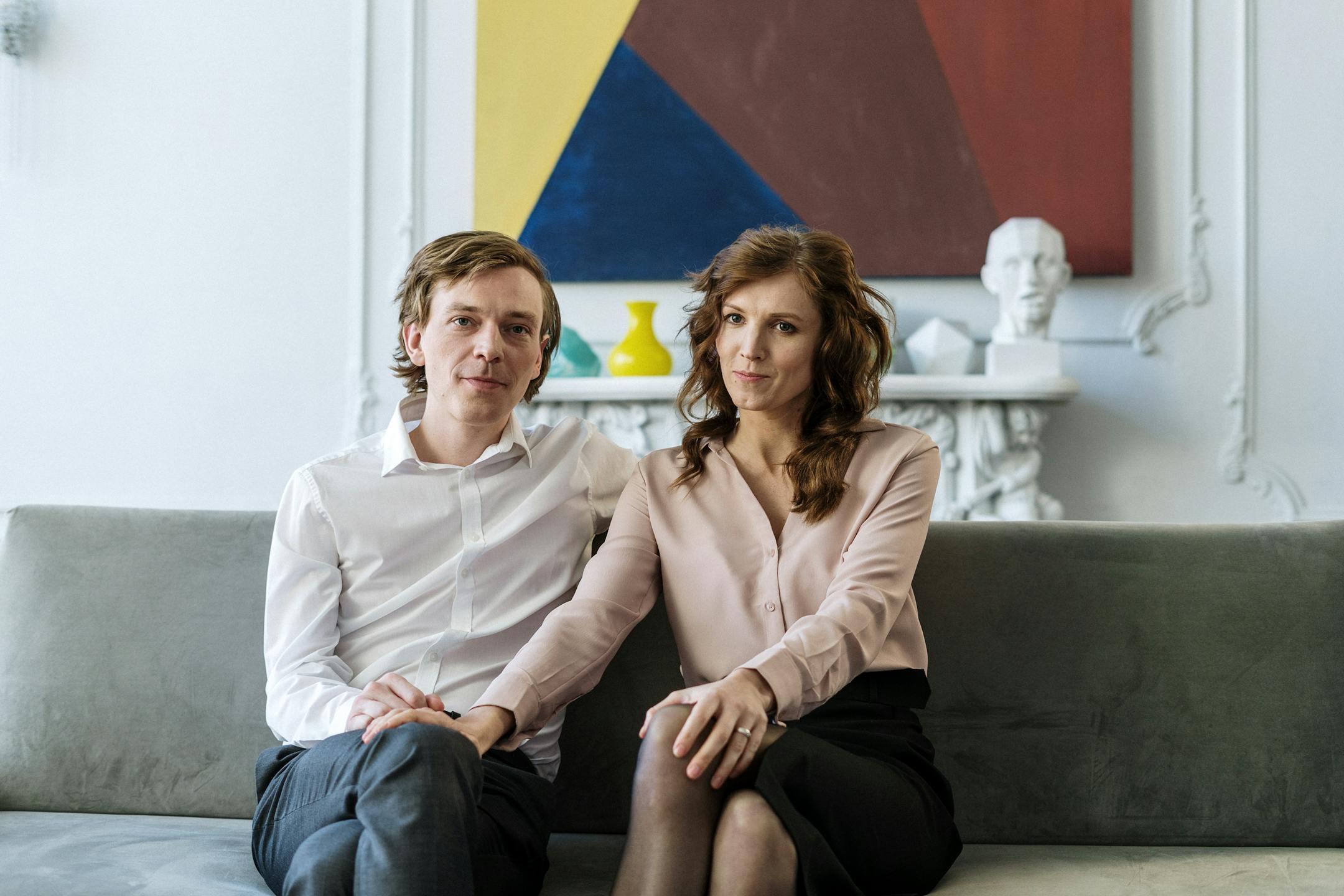 A couple sitting on a couch during a counseling session, showing connection and support.