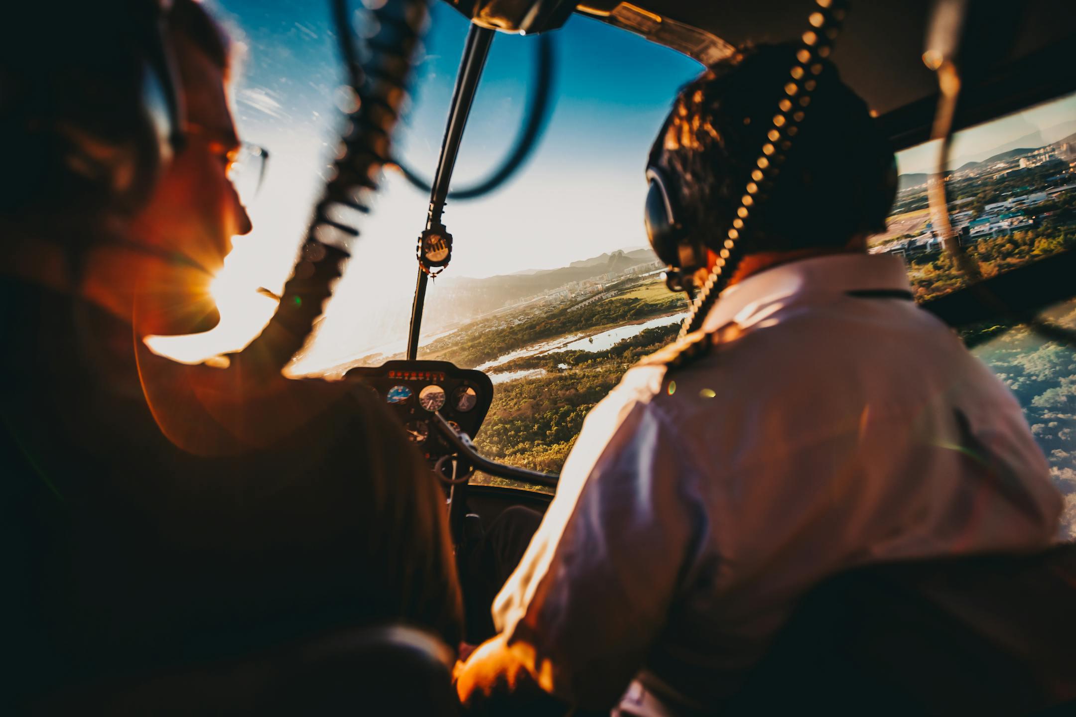 Two pilots navigate a helicopter over Rio de Janeiro during a stunning sunset, capturing the aerial adventure.