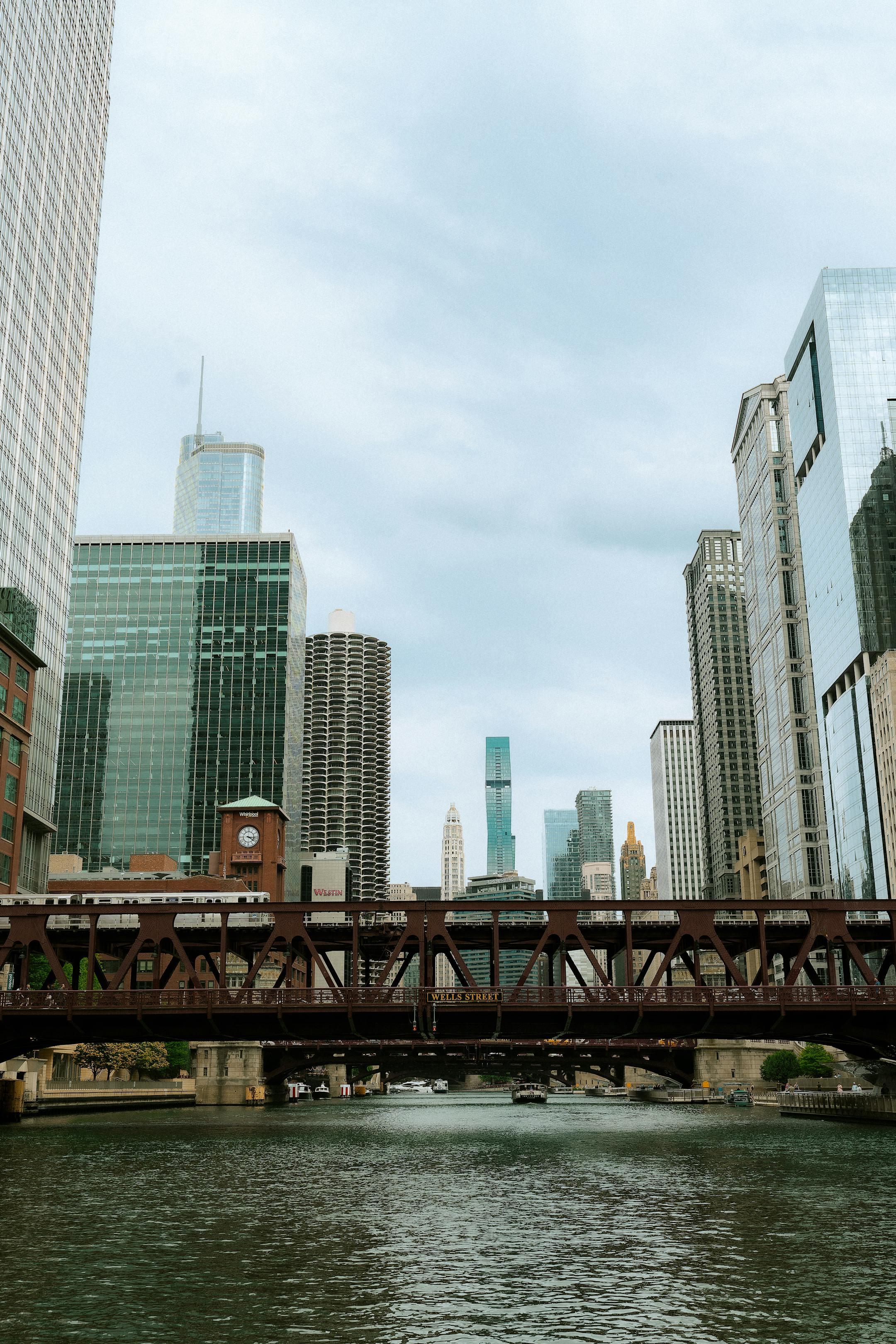 View of Chicago's skyline featuring the iconic bridge and towering skyscrapers on a cloudy day.