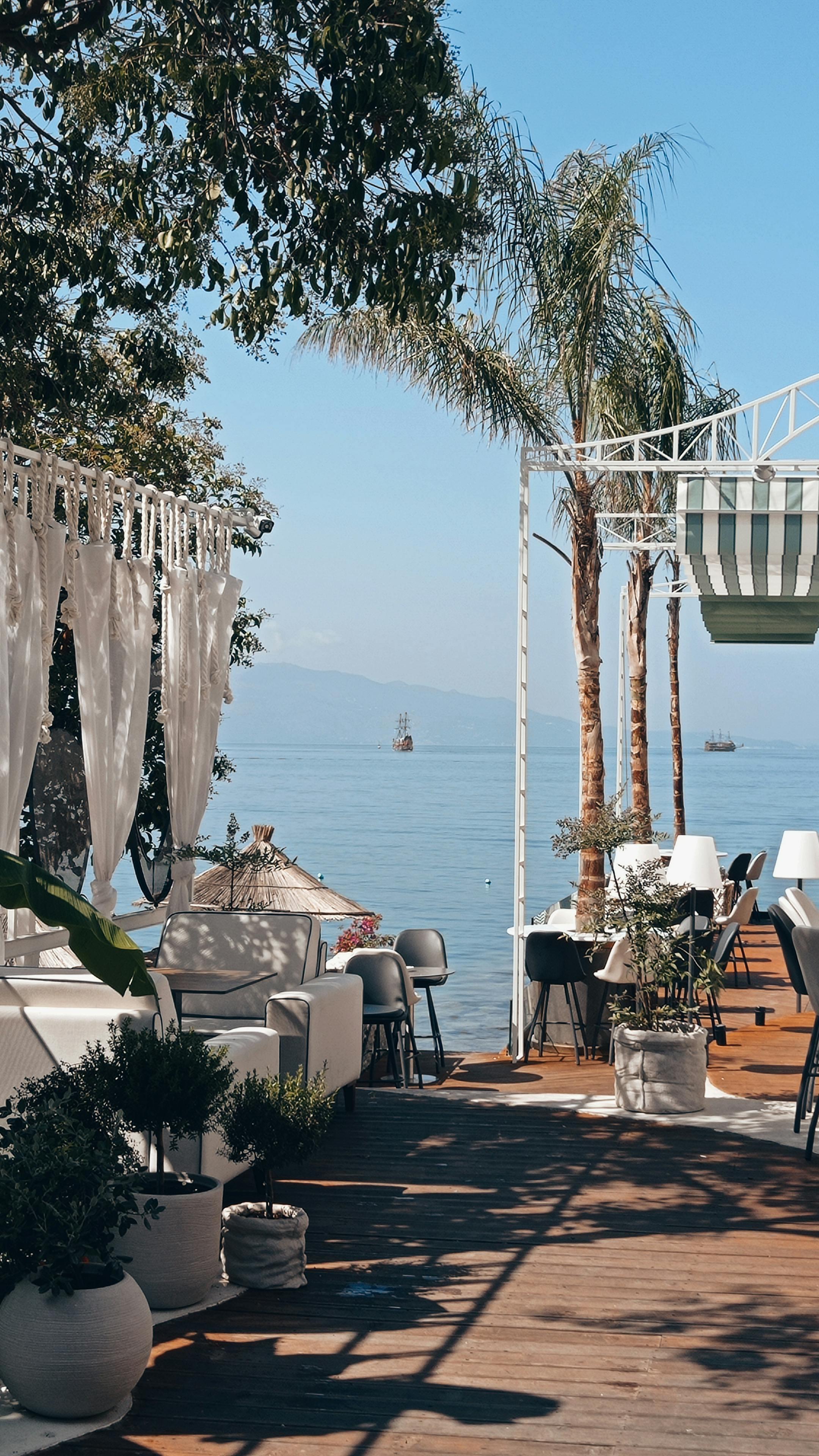 A serene lakeside terrace in Saranda, Albania, featuring seating and a stunning view.