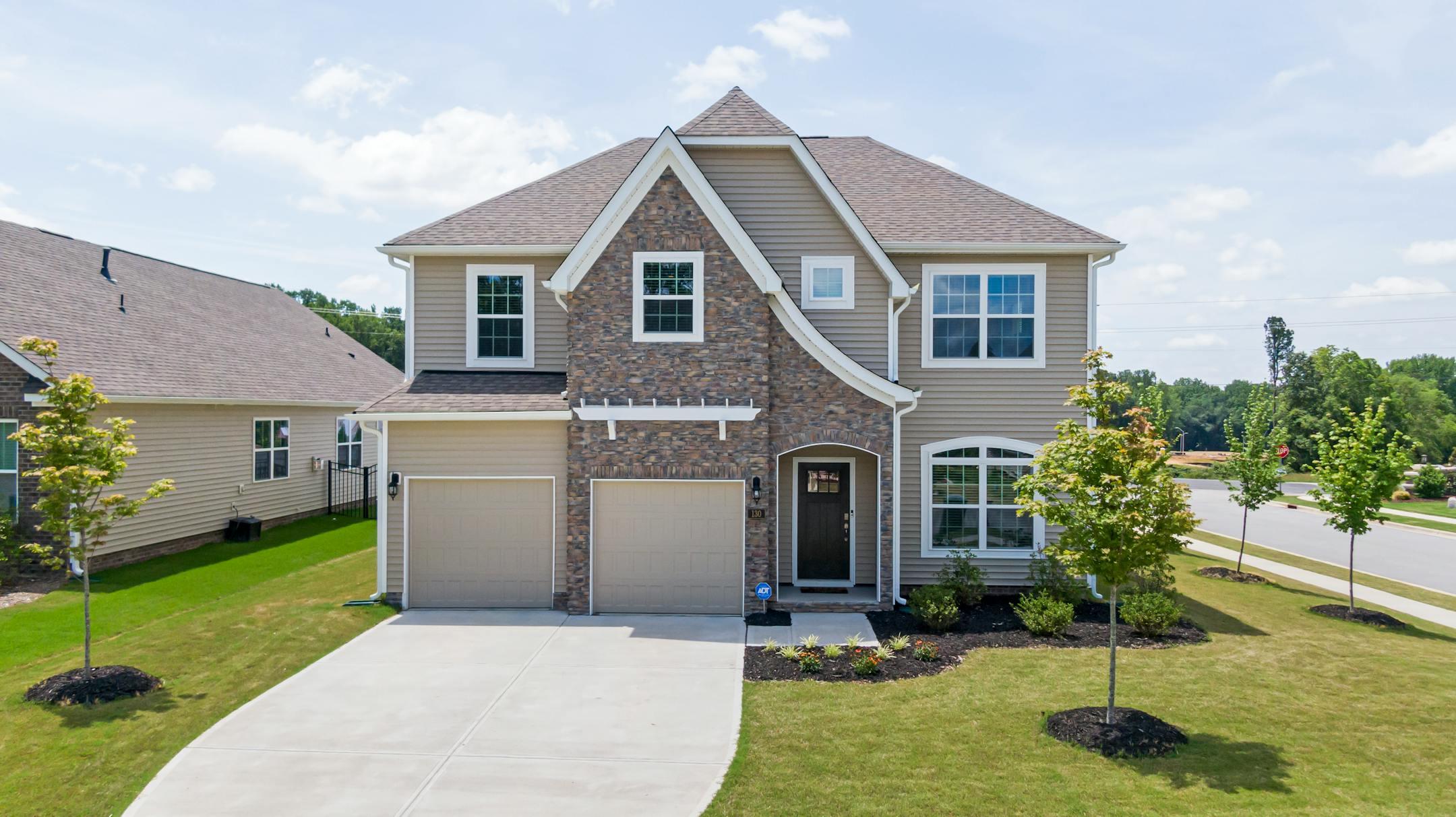 Charming modern family home with a brick facade, landscaped yard, and double garage in Garner, NC.