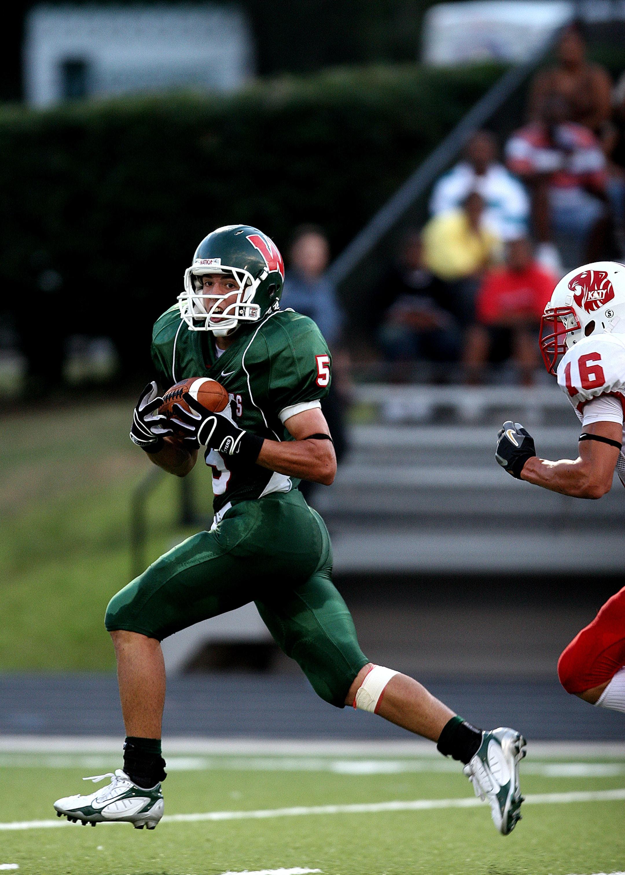 High school receiver pulls away from a defender after catching a pass in a pre-season game in Texas.