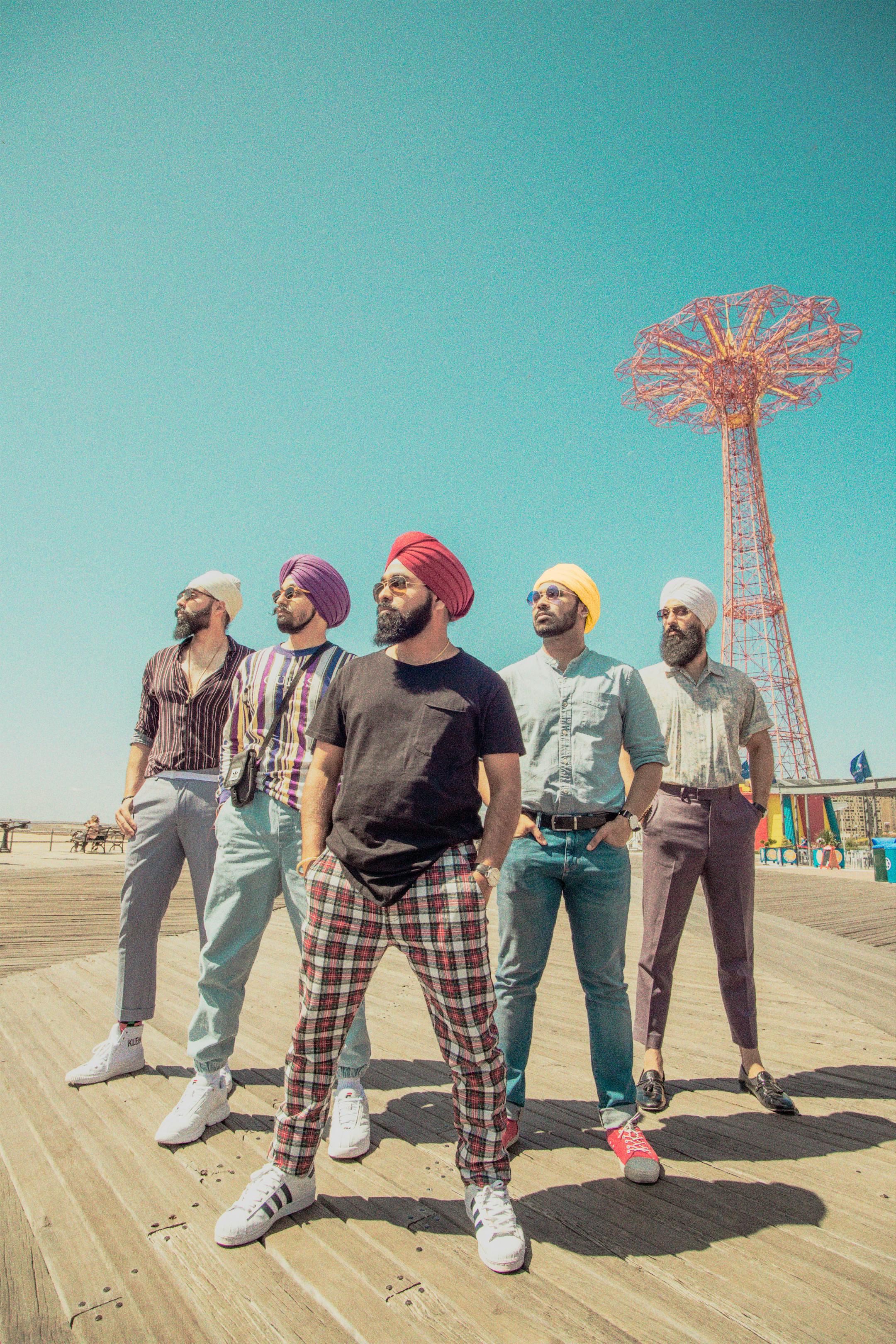 A vibrant group photoshoot at Coney Island with men in stylish outfits and turbans.