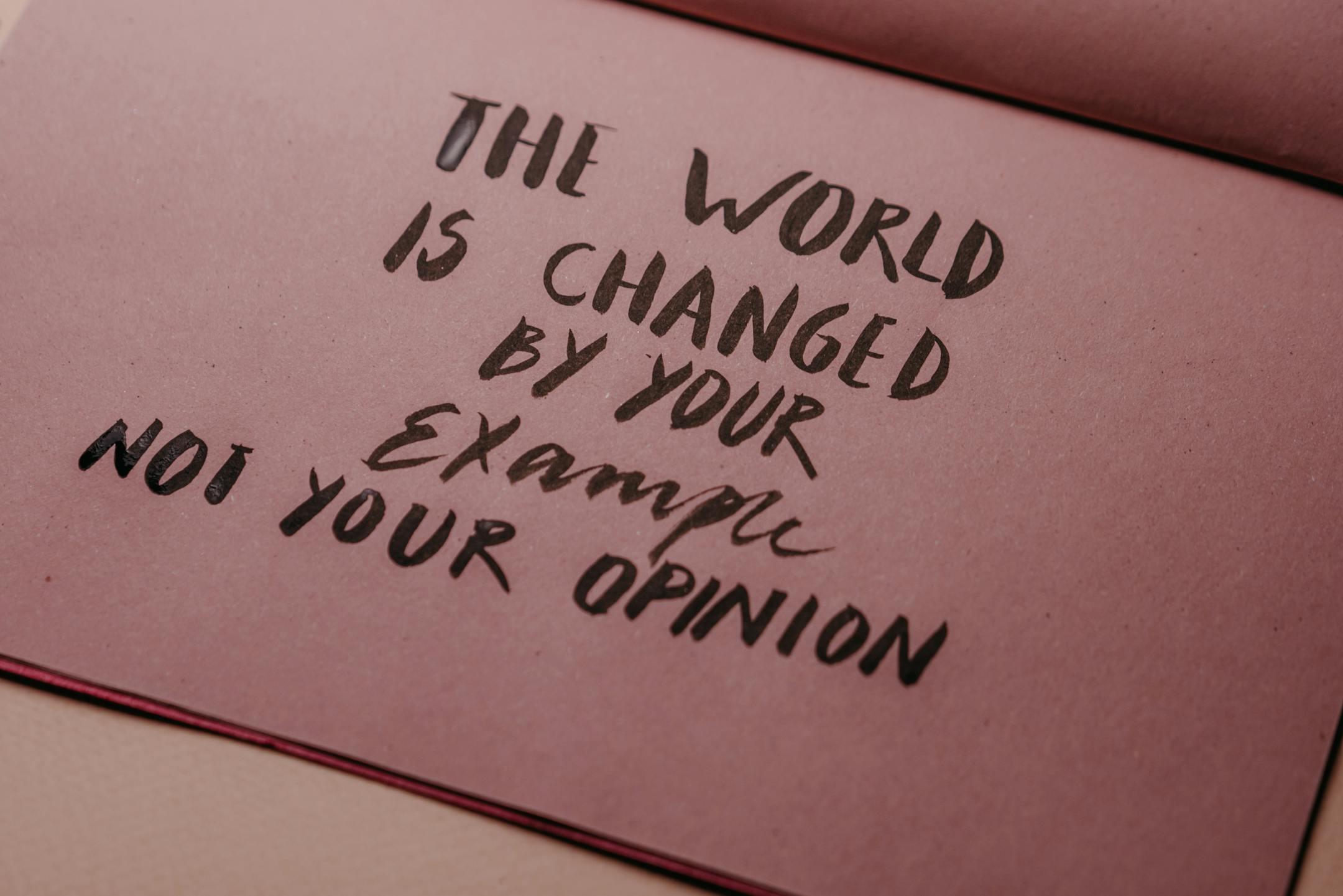 Motivational phrase emphasizing actions over words displayed on textured paper.