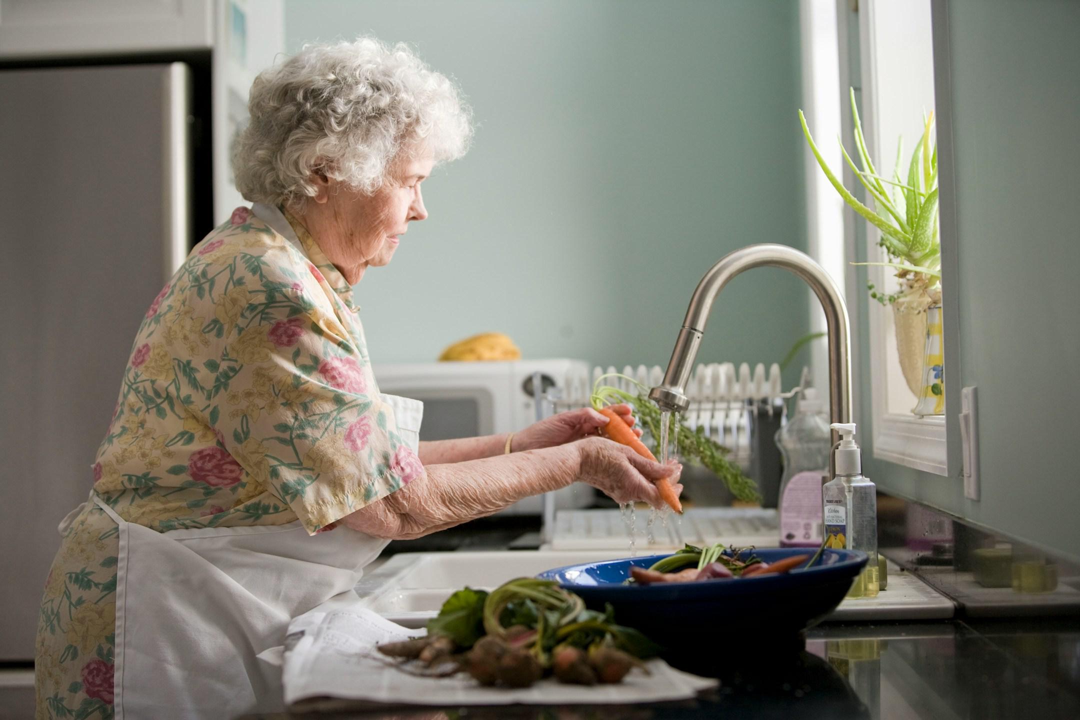 Elderly woman cleaning vegetables. Photo by Cade Martin