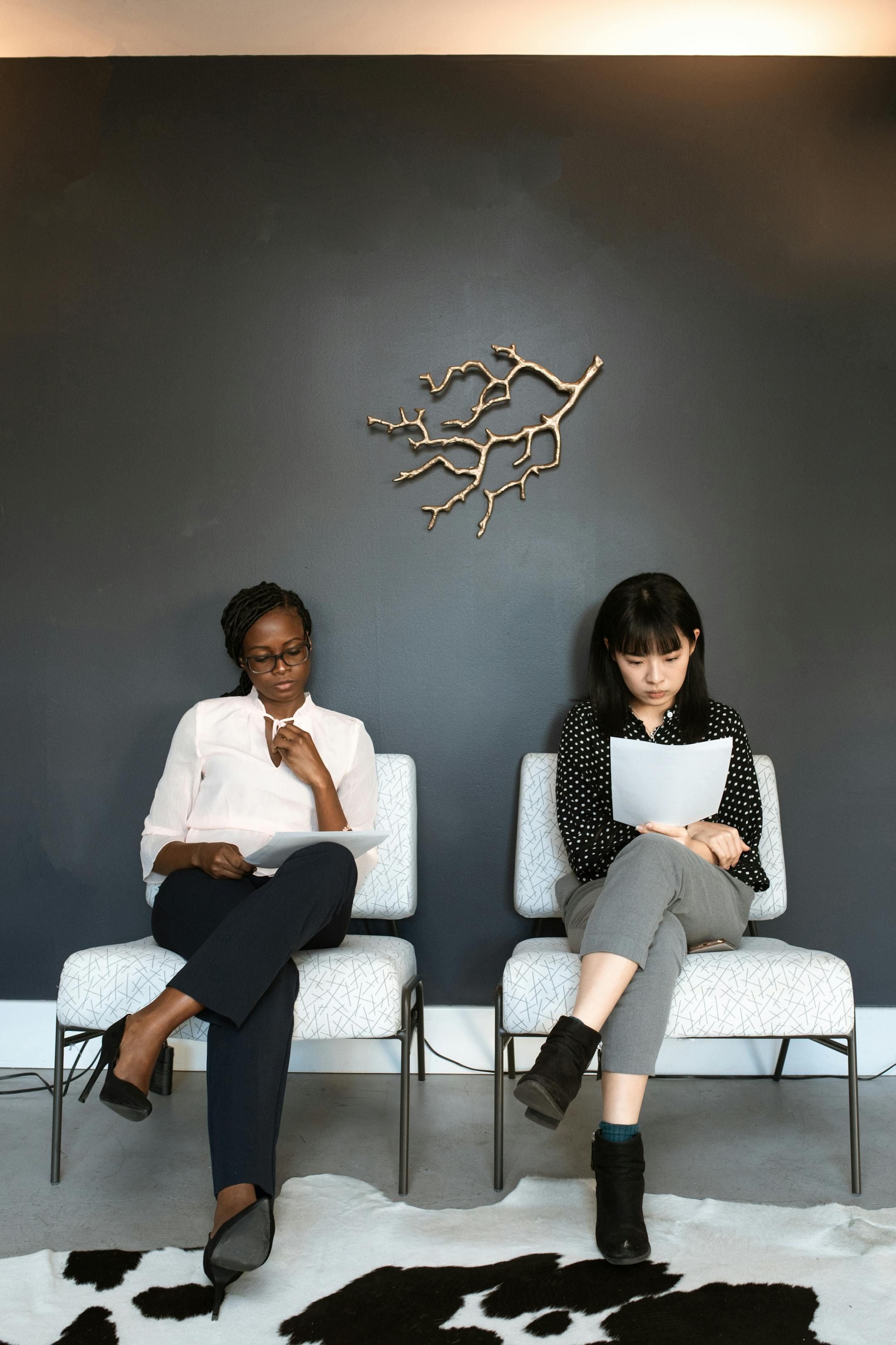 Two women sitting in an office, preparing for interviews.