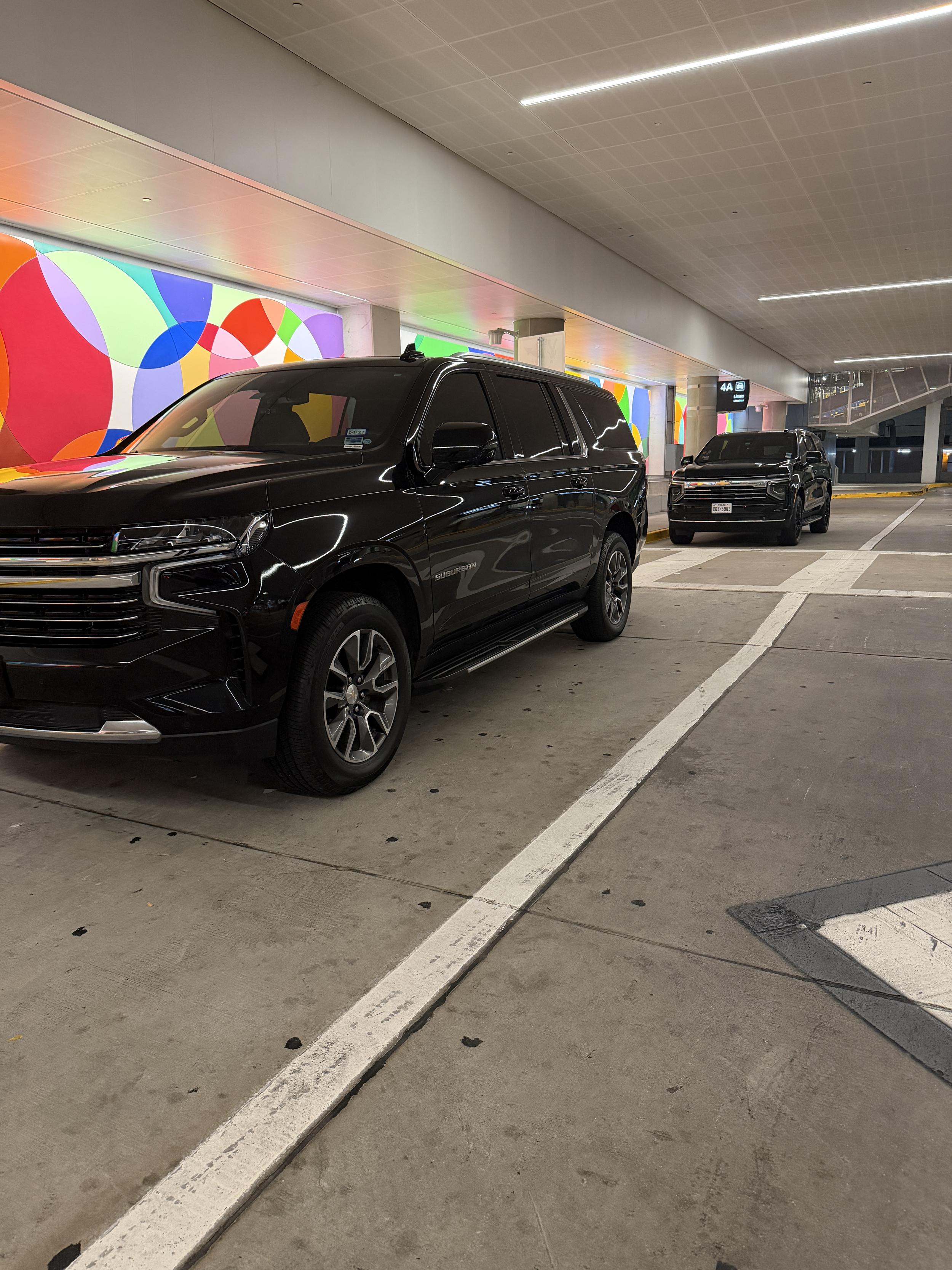 BlackLuxe Ride black Chevrolet Suburban waiting in a Houston airport parking garage