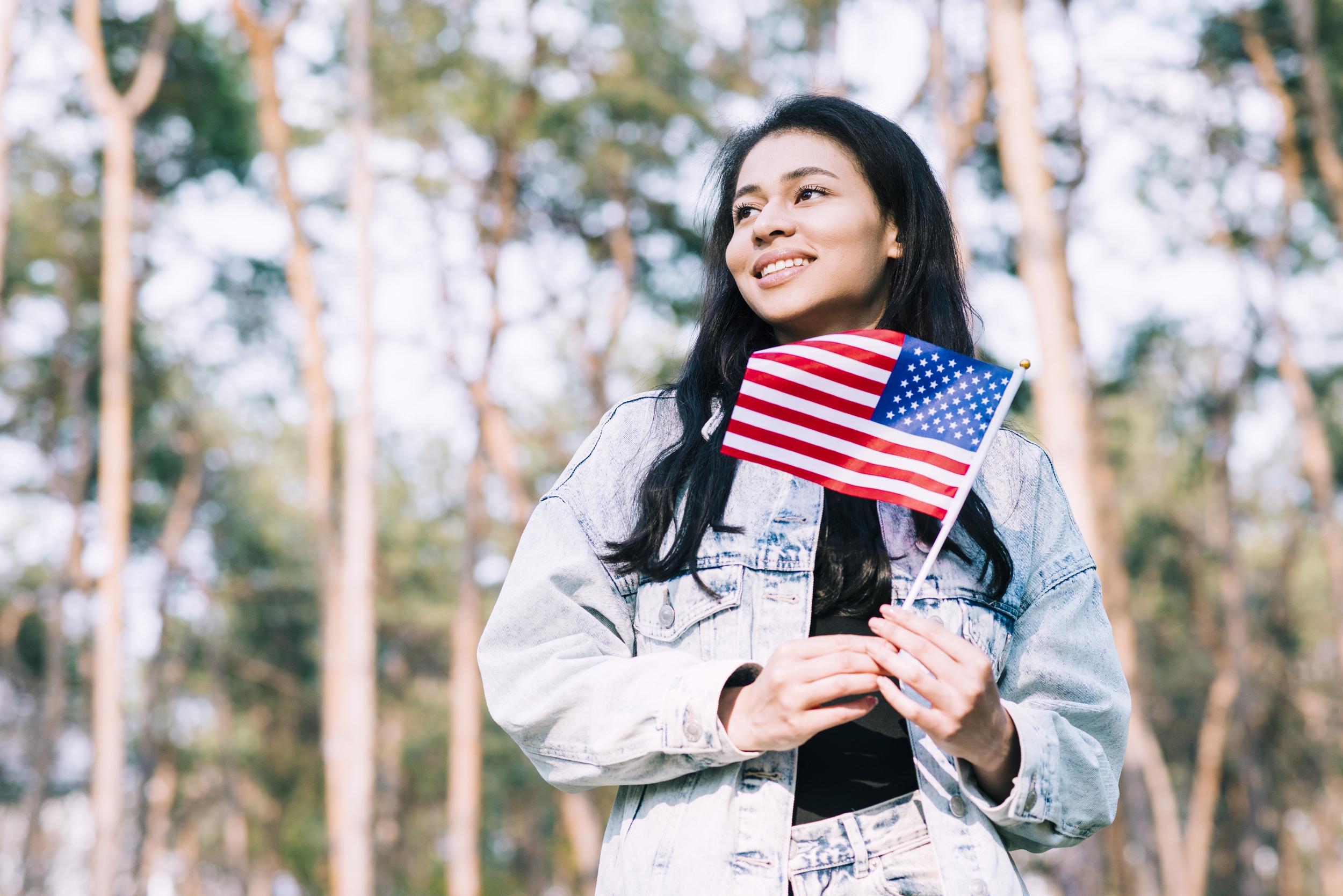 123f43d8-520d-11eb-b022-0242ac110003-hispanic-teenage-girl-holding-american-flag-stick.jpg