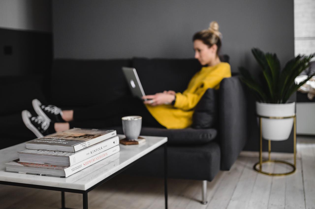 b49f kaboompics Young woman sitting on the sofa and working