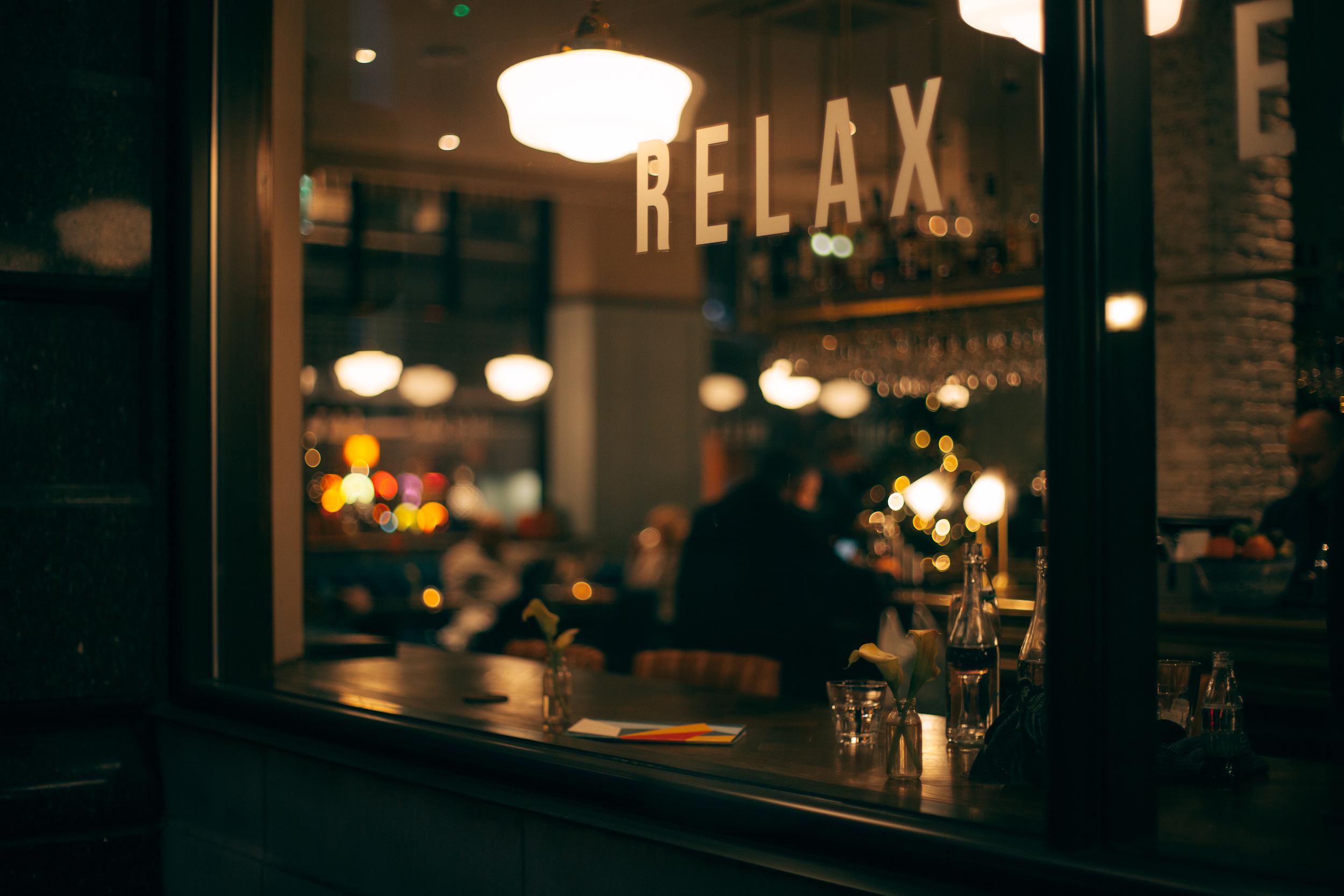 A bar counter with a sign that says "relax" hanging over it.
