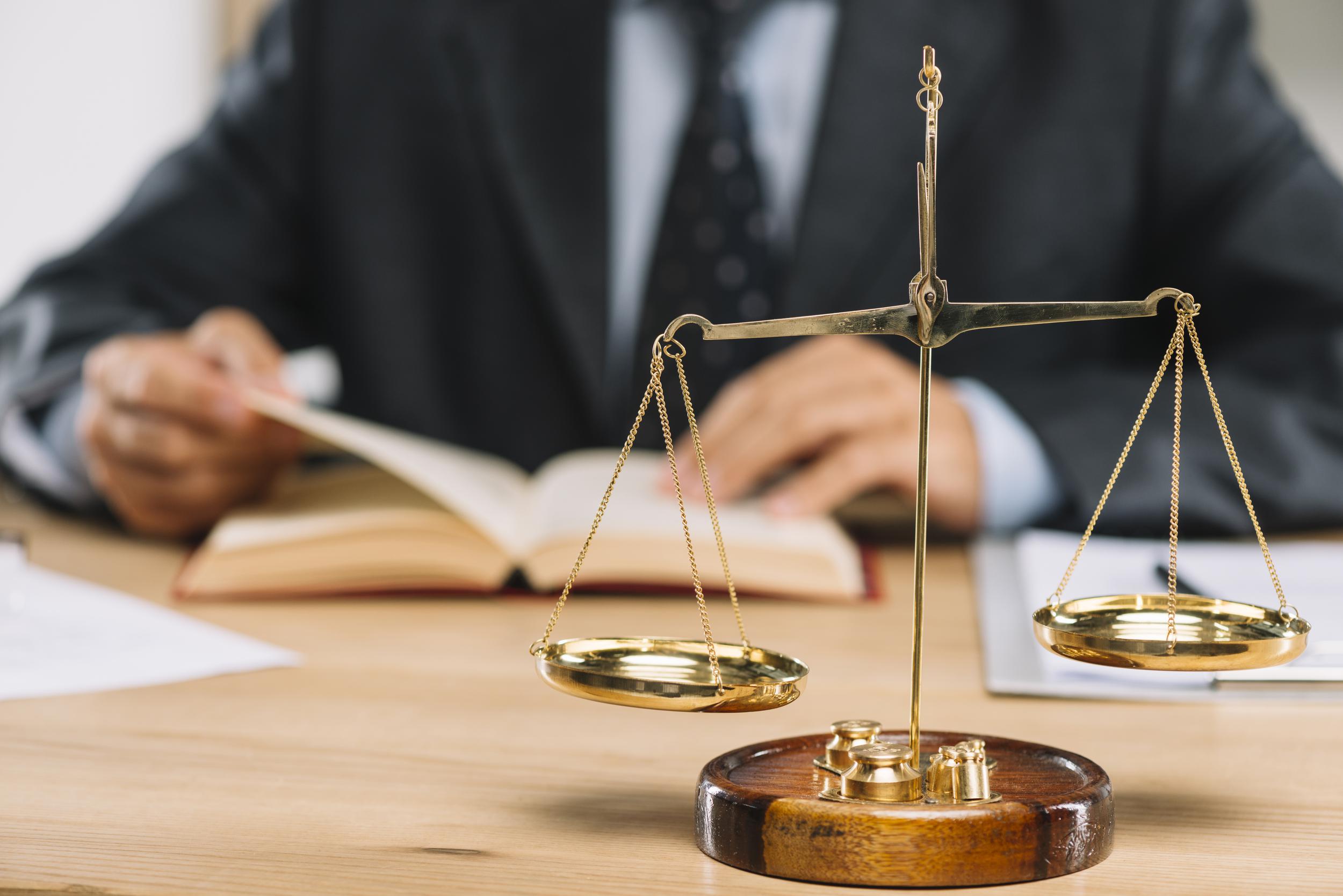 11eb golden justice scale front lawyer reading book table