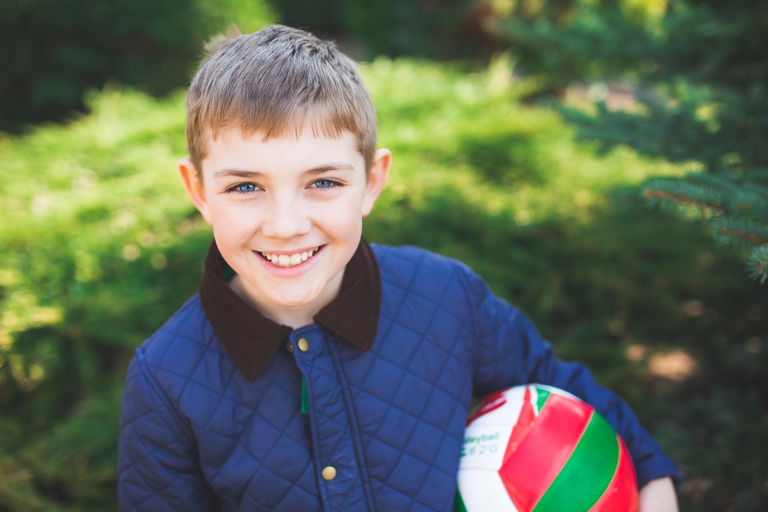 portrait of a smiling young boy with a ball